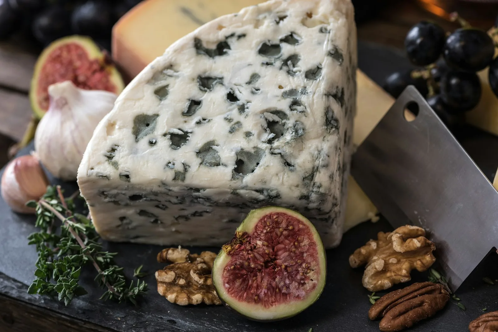 A cheese and charcuterie board with figs and walnuts